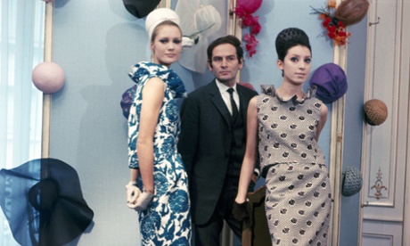 Fashion designer Pierre Cardin poses with two of his models, 1960s