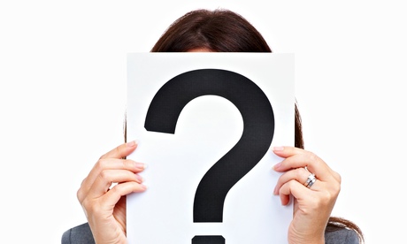 A woman covering her face with a question mark sign