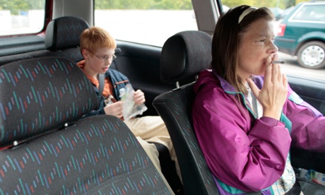 A mother smoking while driving with her son in the car