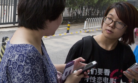 Wei Tingting, right, waits outside a court in Beijing last year. Wei is one of five female activists detained for planning to put up anti-sexual harassment posters.
