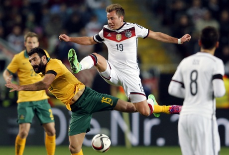 Mile Jedinak and Mario Goetze challenge for the ball.