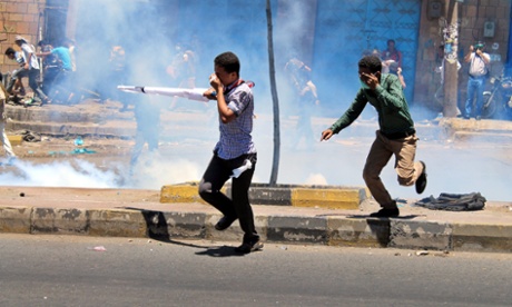 Yemenis run for cover as Houthis fire tear gas at a protest against their presence in Taiz, Yemen.