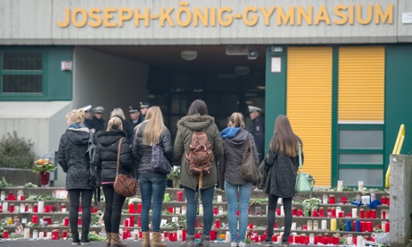 Students stand by candles placed in front of the Joseph Koenig School before school starts in Haltern, Germany