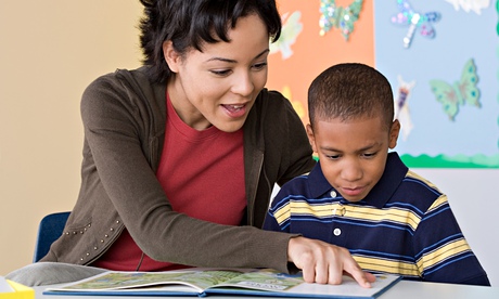 Teacher and pupil reading book