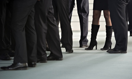 A woman stands surrounded by men