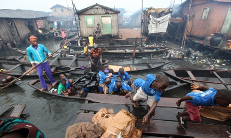 School children dash off a canoe in the rain in Makoko
