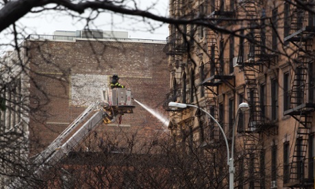 A firefighter directs water onto the site of an explosion and fire in the East Village neighborhood of New York on Friday 27 March 2015.