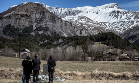 People pay tribute in front of a memorial plaque, carved in French, German, Spanish and English, in memory of the victims of the Germanwings Airbus A320 crash, in the small village of Le Vernet, French Alps.