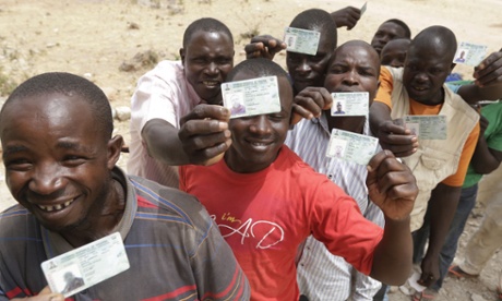 People displaced by Islamist militants display their voting cards in Yola, Nigeria.