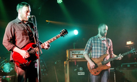 Barry Burns and Dominic Aitchison of Mogwai perform on stage in the UK, in 2014.