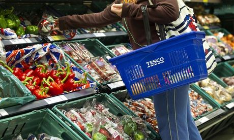 A customer browses the fruit and vegetable aisle in a Tesco Metro store.
