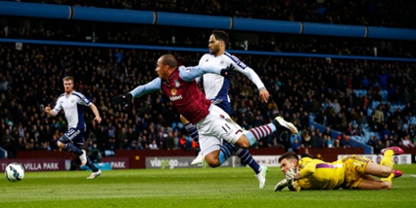 Agbonlahor nudges the ball past Ben Foster but  Joleon Lescott, centre, sprints in to clear the ball off the line.