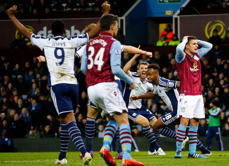 Then celebrates as the Villa players despair.