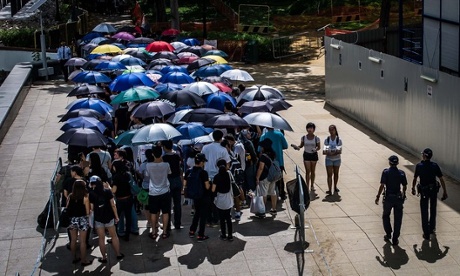 A section of the queue to pay tribute to Lee Kuan Yew alongside the Singapore River shelters under umbrellas from the searing afternoon sun.