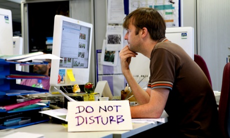 Man at desk with do not disturb sign.