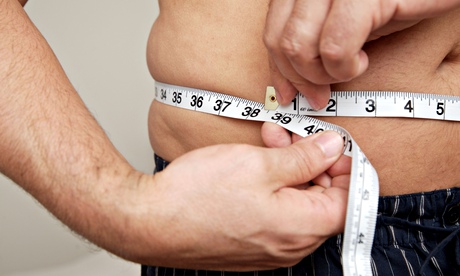 Close up of man measuring waist with tape measure. Image shot 2010. Exact date unknown.
