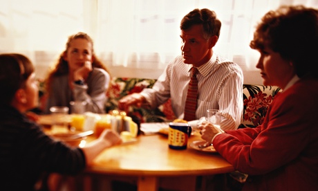 Bored teenager at breakfast with sister, mother and father in a tie