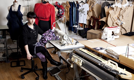 Eco fashion designer Ada Zanditon at a table with clothes behind her