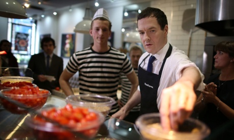 The chancellor, George Osborne, makes pizza with the help of a staff member during a visit to Pizza Express in Hove on Tuesday.
