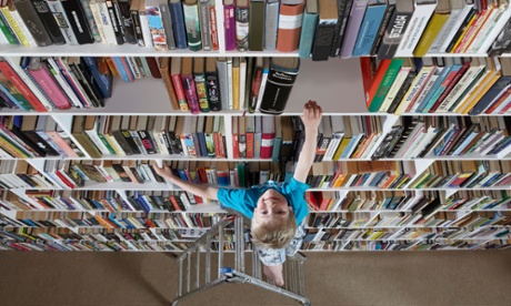 Boy climbing up bookshelf