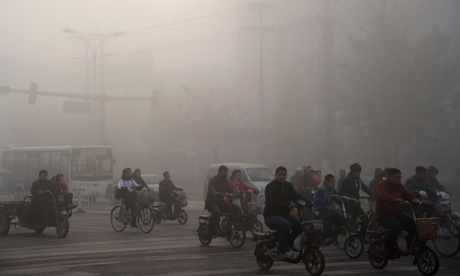 People cycle through the haze-filled streets in Xingtai, Hebei province, China