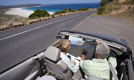 An older couple in a convertible car