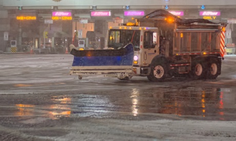 Crews salt and clear the roadway in front of the New Jersey entrance to the Holland Tunnel.