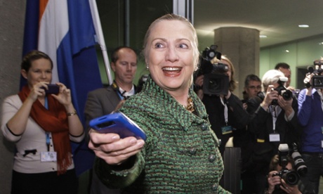 In a 2011 photo, then-Secretary of State Hillary Clinton hands off her mobile phone in The Hague, Netherlands.