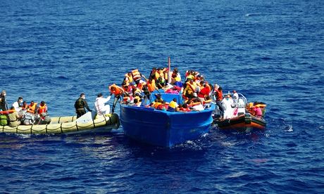 Italian navy rescuers help refugees to climb on to their boat in the Mediterranean. Photograph: AFP/