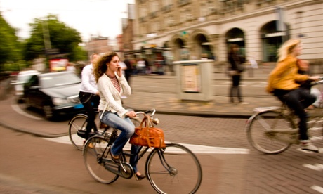 woman talking on mobile-phone whilst cycling in Amsterdam