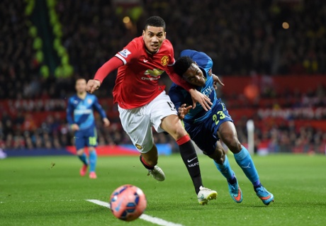 Chris Smalling of Manchester United and Arsenal's Danny Welbeck tussle for the ball.