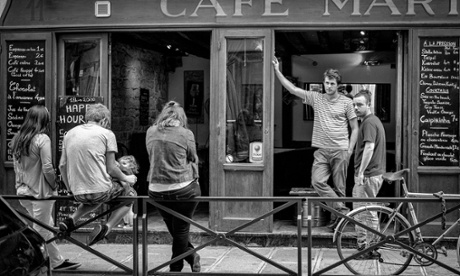 People on the street outside of a French cafe