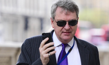 Lynton Crosby with a mobile and sunglasses