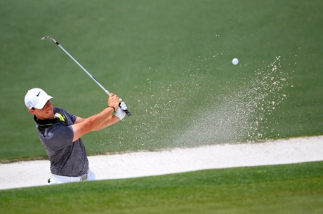 Rory McIlroy plays a bunker shot on the second.