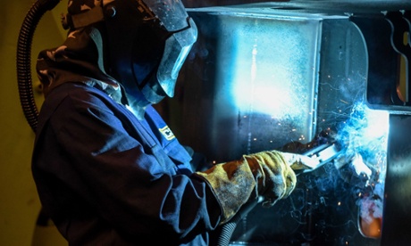 A welder works on a part of a JCB telescopic handler.