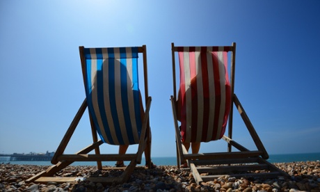 People relax in deck chairs on the beach in Brighton on July 18, 2014, as parts of the country were expected to experience the hottest day of the year so far and the Met Office issued a heatwave alert for southern England and the Midlands.  AFP PHOTO / CARL COURT        (Photo credit should read CARL COURT/AFP/Getty Images)HORIZONTAL|ILLUSTRATION|COUPLE|DECKCHAIR|SEASON|SUMMER|HEAT|HOLILEISUREANDDAILYLIFE|BEACH|SEA