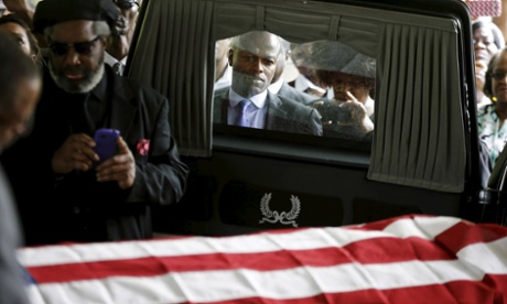 Mourners, and ABC News correspondent Kendis Gibson, look on as the casket of Walter Scott is removed from a hearse for his funeral at WORD Ministries Christian Center.