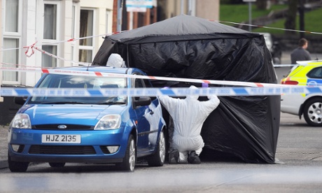 Police officers examine the car in which the body of a man was found south Belfast.