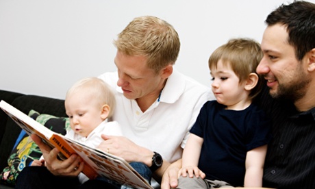 Fathers reading a book to their children 