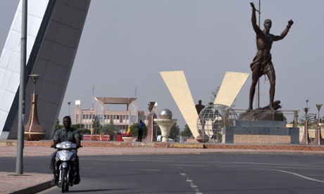 A man on a motorbike rides past La Place de la Nation (Nation Square) in N'Djamena.