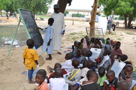 Children who fled their homes following an attacked by Islamist militants in Bama, take a lesson at a camp in Maiduguri, Nigeria