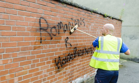 A council worker removes racist graffiti from a wall in east Belfast.
