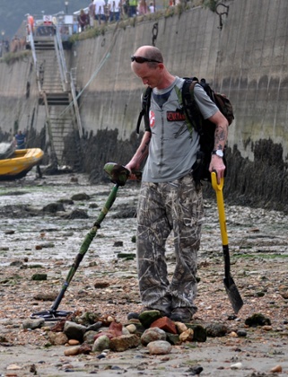 John Knott working the beach with a metal detector