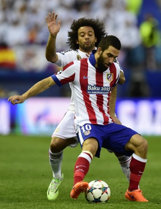 Atletico Madrid's Arda Turan shields the ball from Marcelo