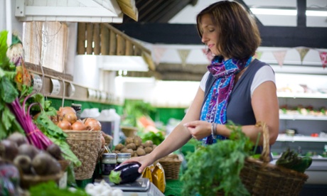 woman picking vegtables from stall