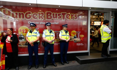AUCKLAND, NEW ZEALAND - APRIL 15:  Police stand on guard as protestors picket outside McDonalds in Britomart on April 15, 2015 in Auckland, New Zealand. McDonald's workers will join thousands of fast-food workers in an International Day Of Action protesting zero-hours contracts.  (Photo by Phil Walter/Getty Images)ConflictWar