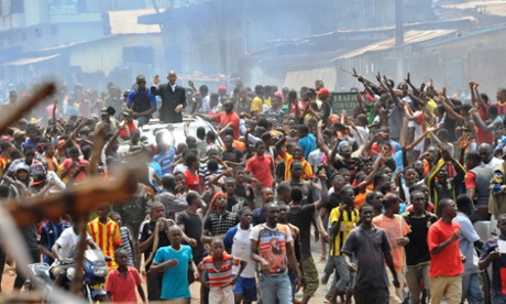 Guinean opposition leader Cellou Dalein Diallo waves on a car surrounded by demonstrators on April 15, 2015 in Conakry as fresh violence erupted in the Guinean capital after a day of clashes between police and anti-government protesters that left one dead and several with gunshot wounds, AFP correspondents witnessed.