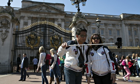 Tourists take a photo at Buckingham Palace using a selfie stick