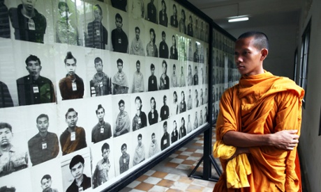 A Cambodian looks at photographs of victims.