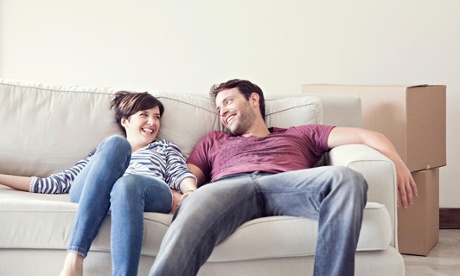 Couple relaxing on sofa while moving house